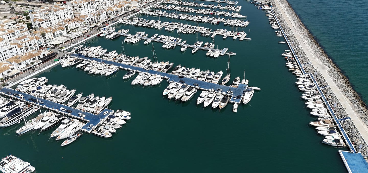 Aerial view of luxury yachts and boats moored in the Puerto Banus marina in Marbella, Spain.