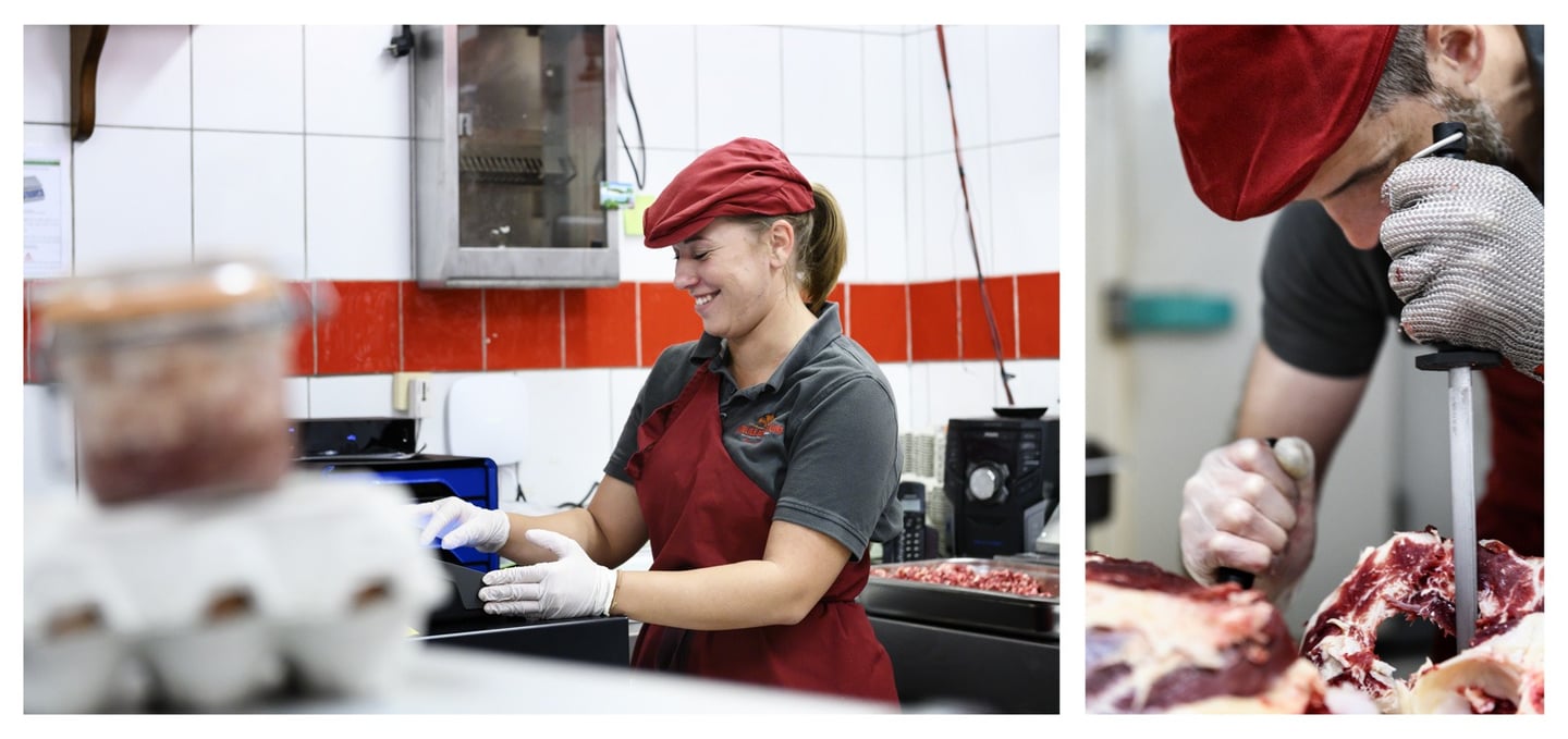 Un boucher découpe un morceau de viande et une vendeuse est dans la boucherie