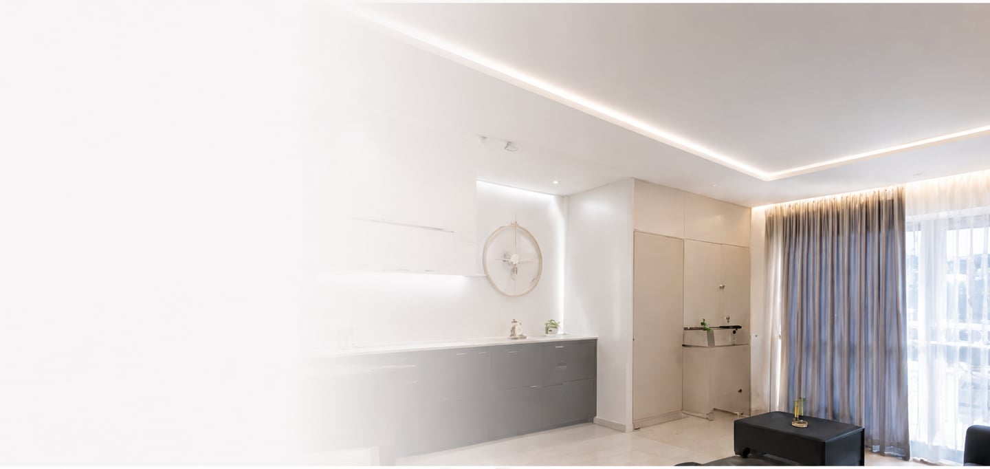Modern living room with recessed ceiling lighting, sleek grey cabinets, and elegant floor-to-ceiling curtains.