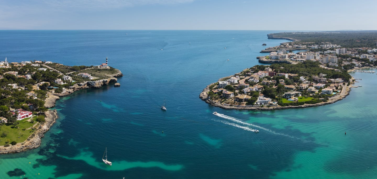 a boat sailing in the ocean near a small island