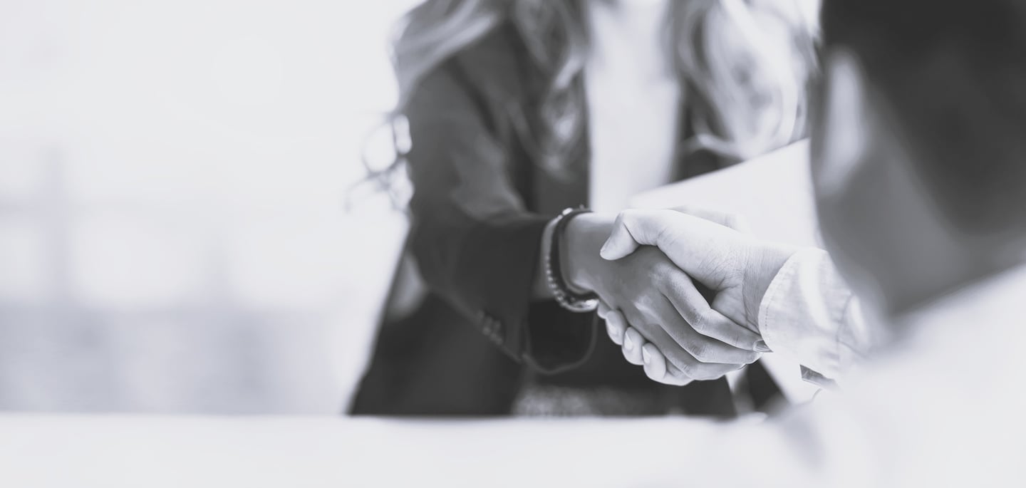 a woman shaking someone's hand over a table