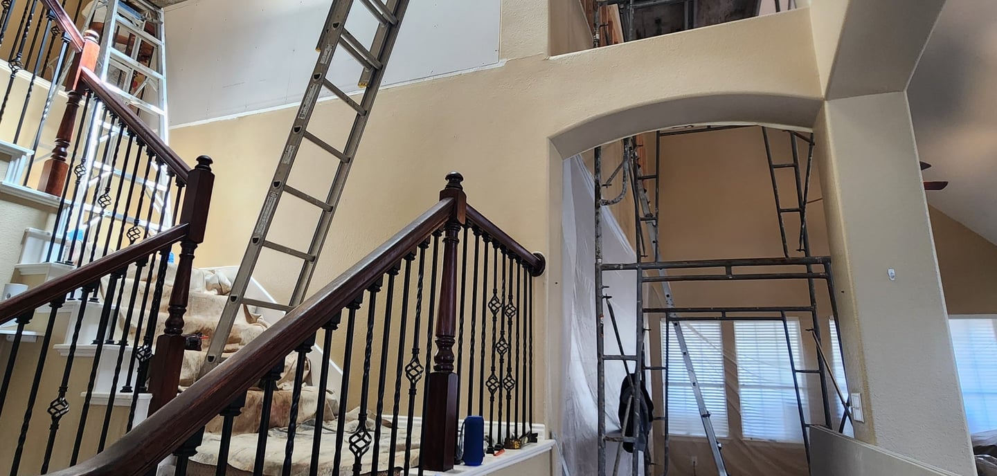 a staircase way with a ladder up to the top of it