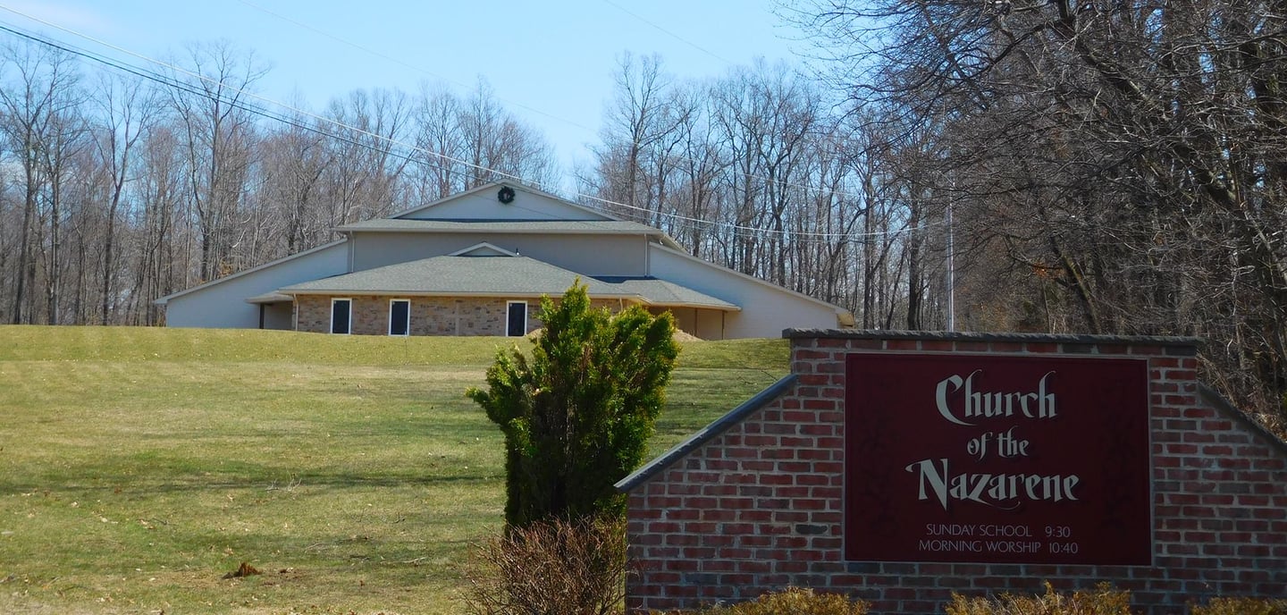 a church sign with a church in the background