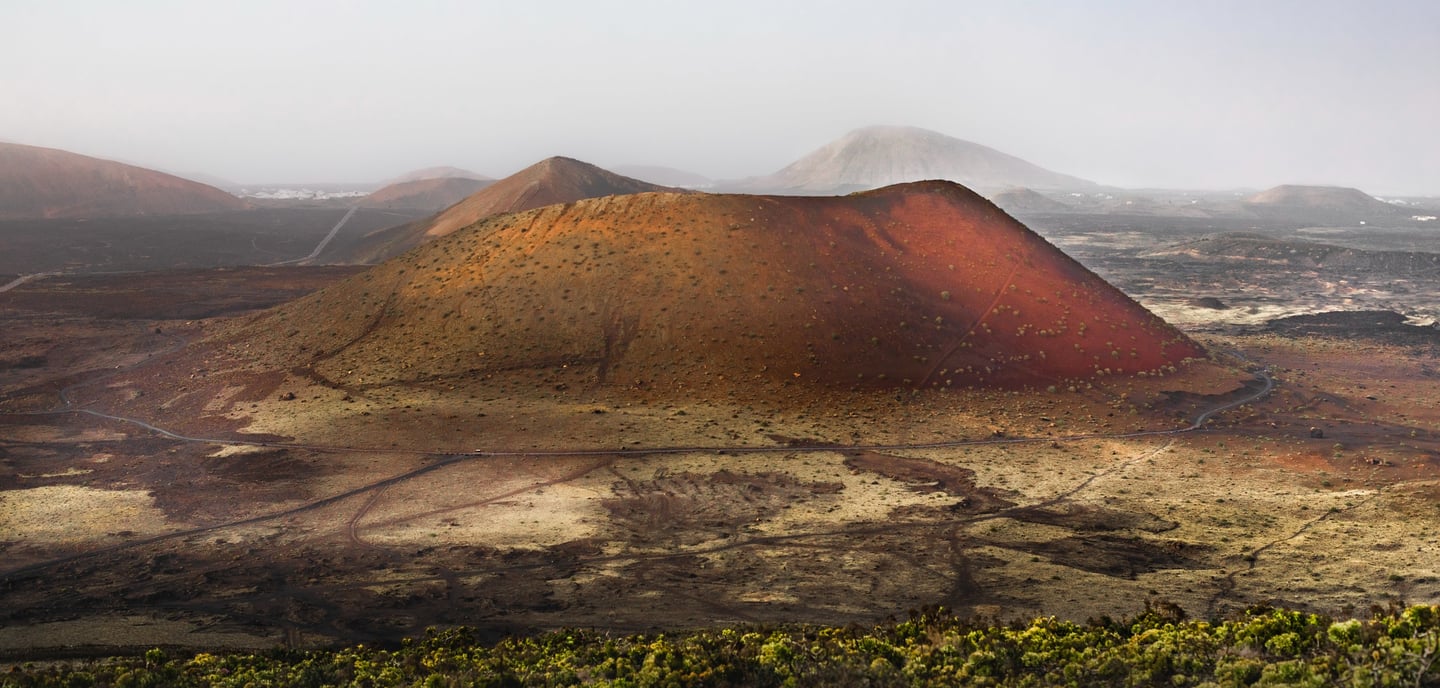 a mountain with a red and yellow mountain in the background