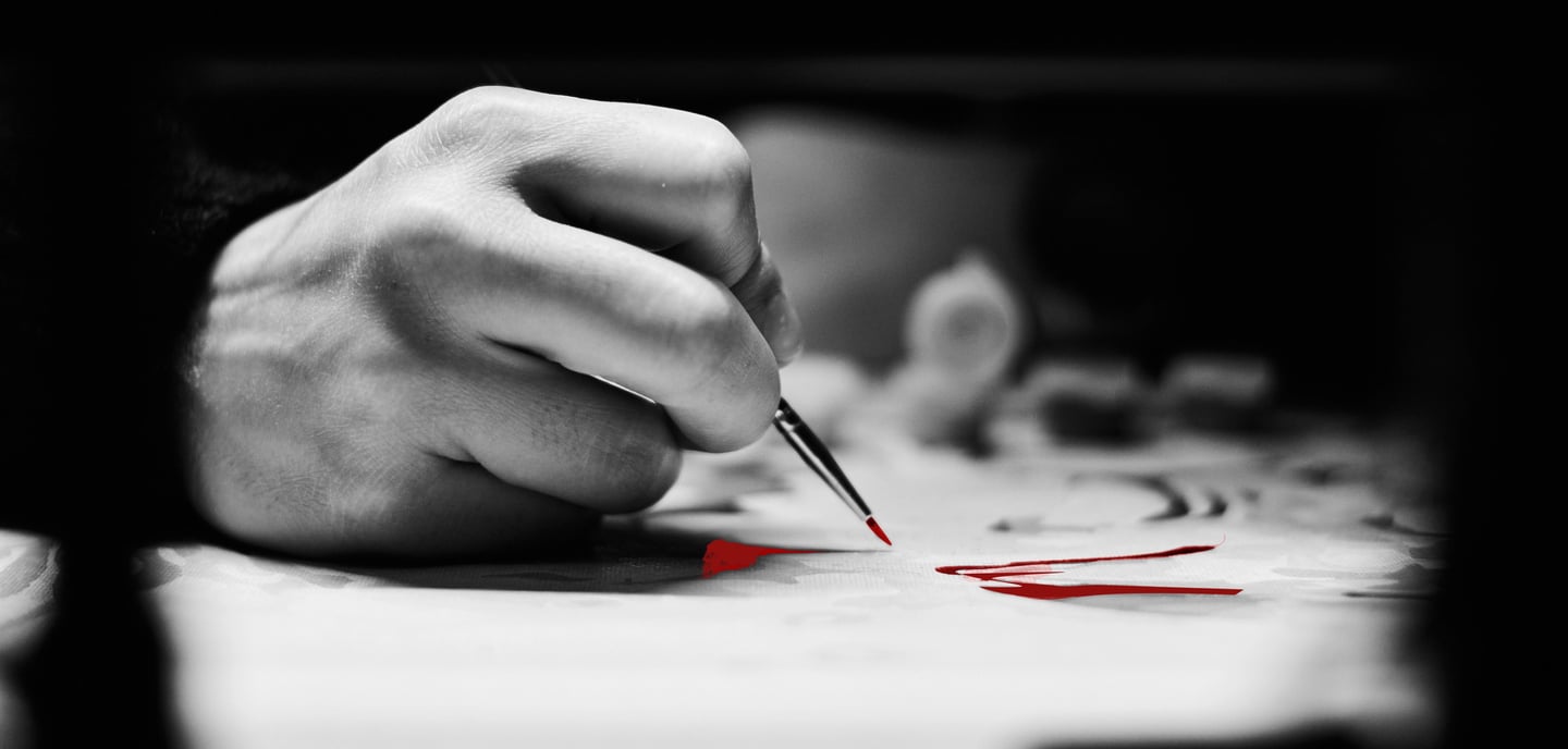 A close-up of a hand holding a paintbrush