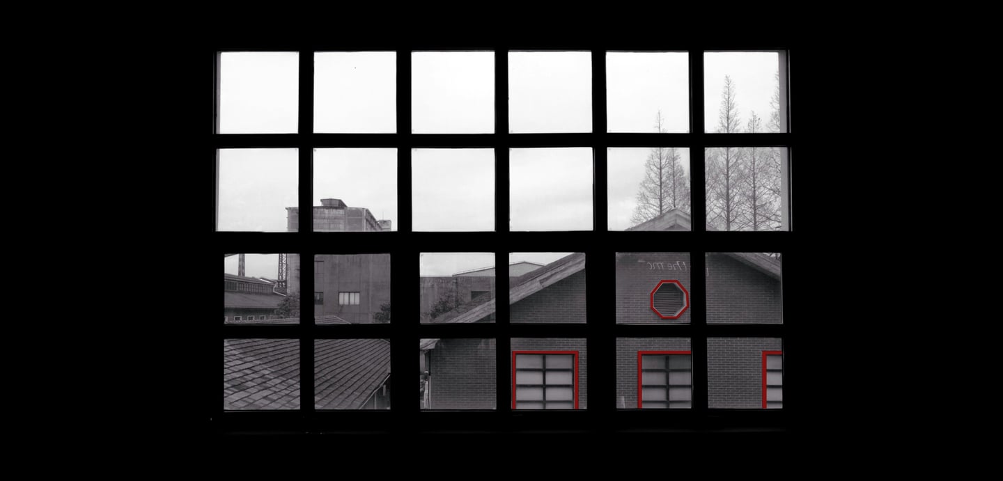 View through window with red-outlined shapes on building