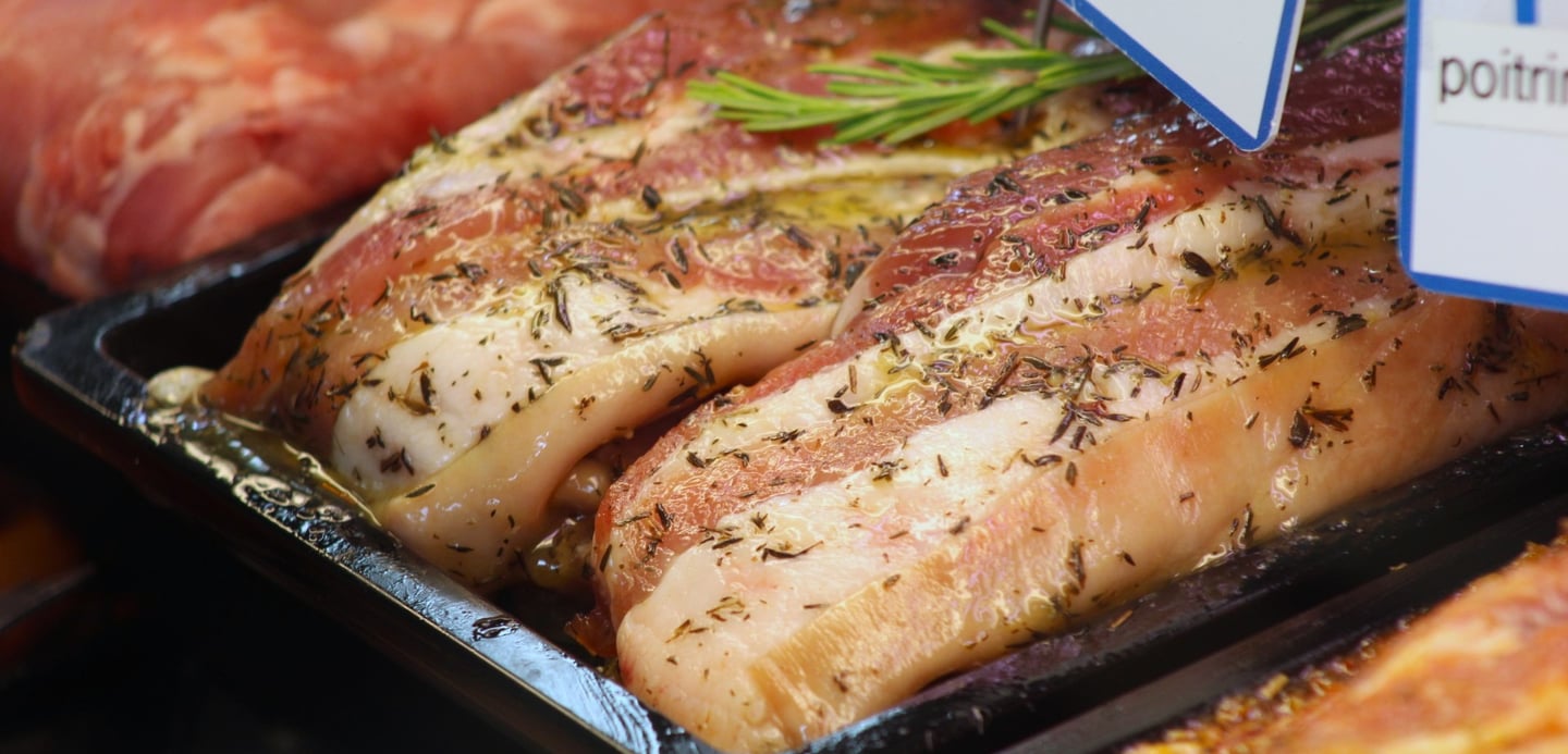 a variety of meats and vegetables in a display case