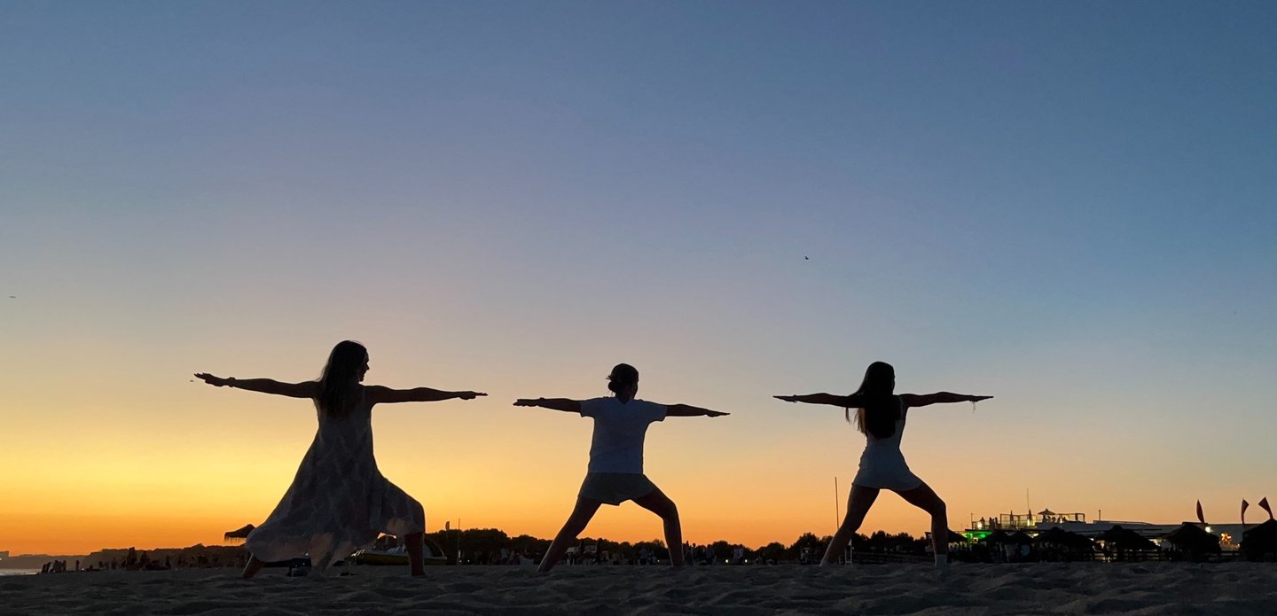 Katie Prickett Warrior 2 pose with daughters on beach