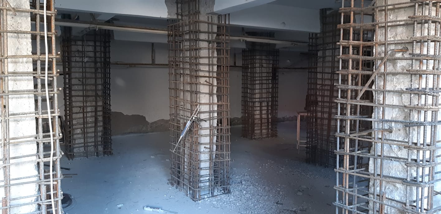 Bir yapının güçlendirme ve onarım aşamalarını gösteren fotoğraf.