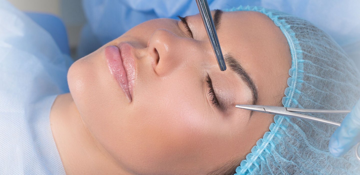 Mulher de olhos fechados em centro cirúrgico aguardando a cirurgia plástica de pálpebras