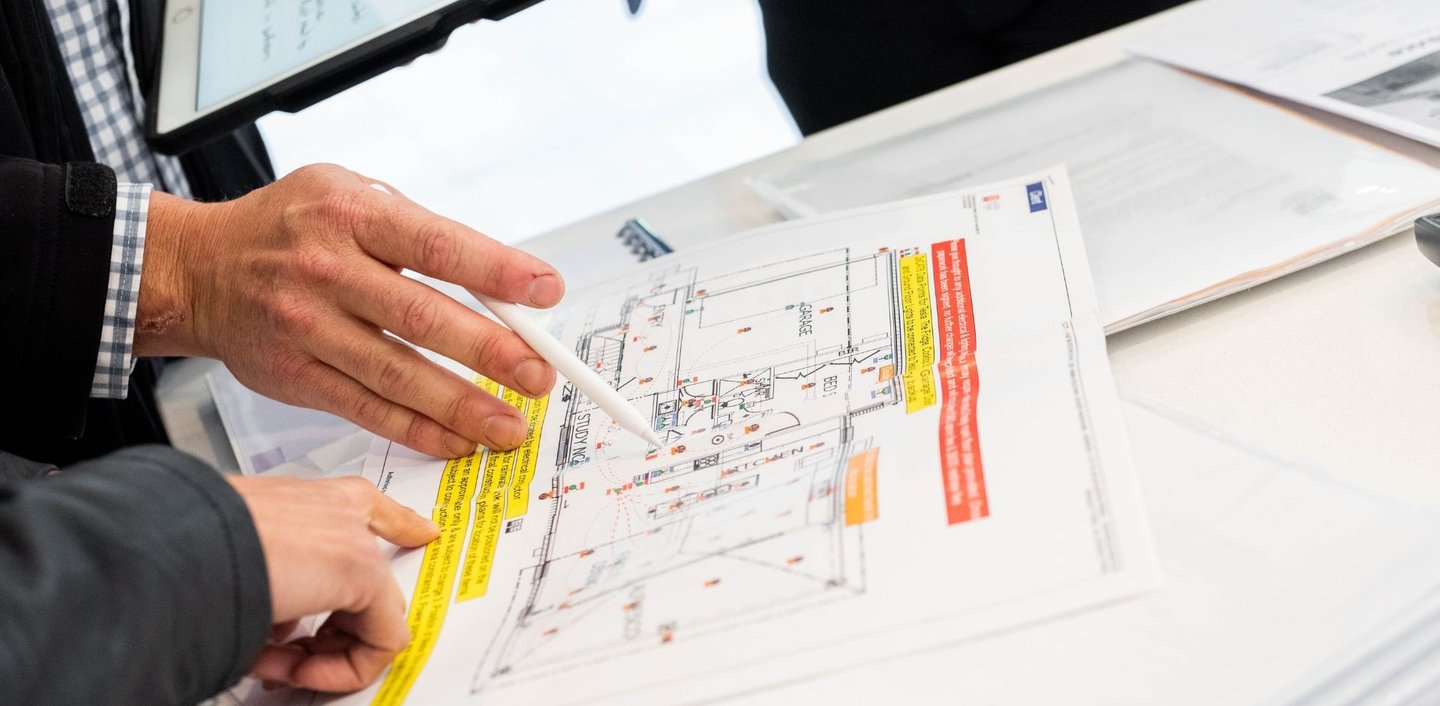 Dwie osoby konsultują projekt i nanoszą zamiany długopisem