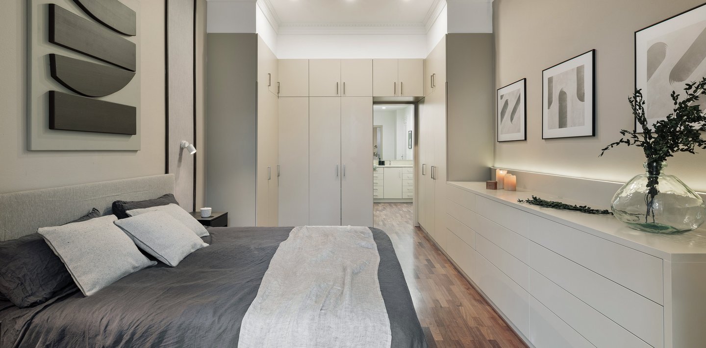 Elegant bedroom design with custom wall panels and bold decor details and integrated wardrobes