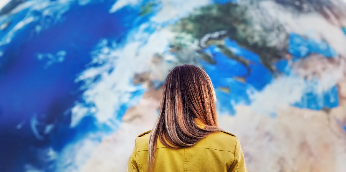 Woman staring at a large world map on a wall