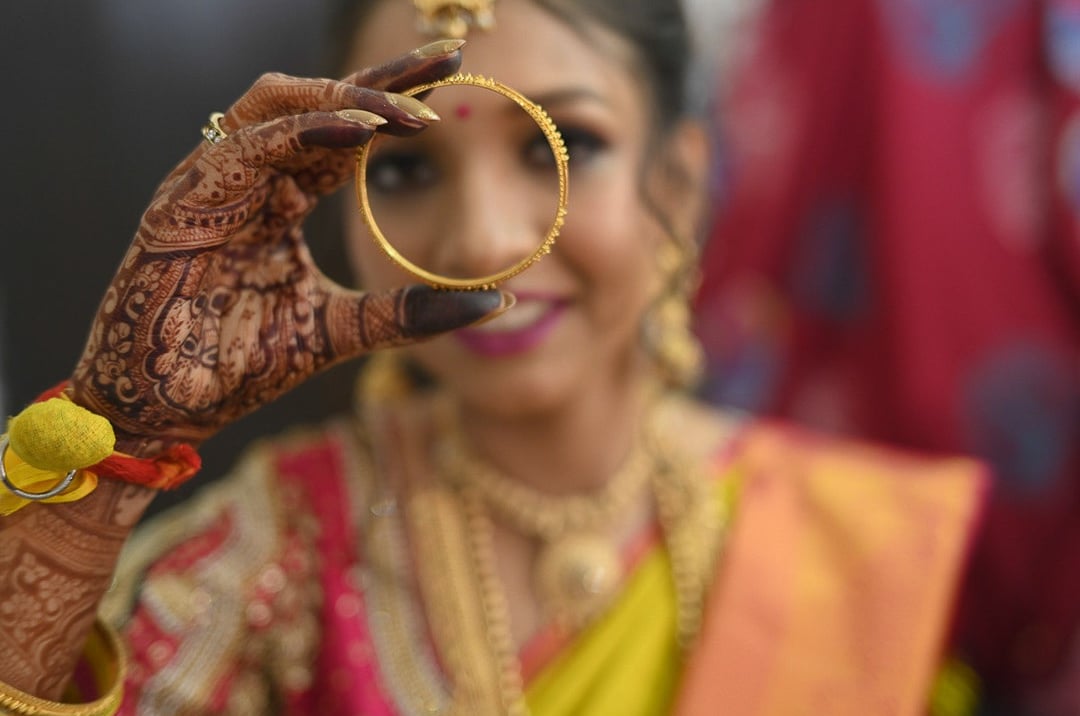Kerala bride showing her bangle during her bridal makeup session