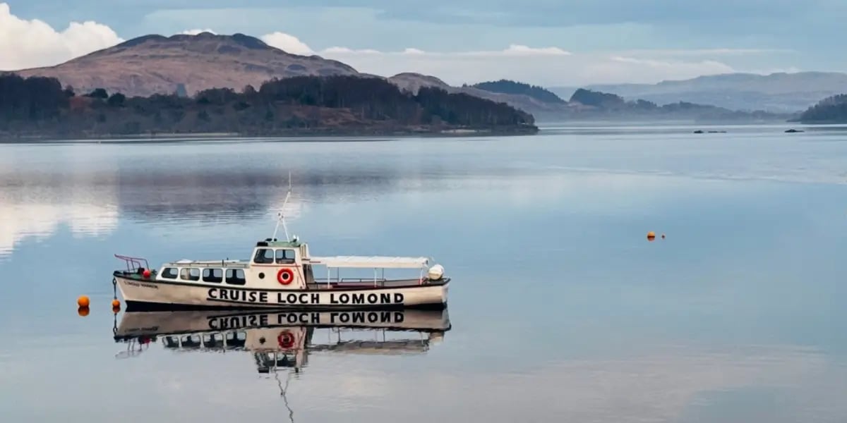 white boat on Loch Lomond with hills in the background