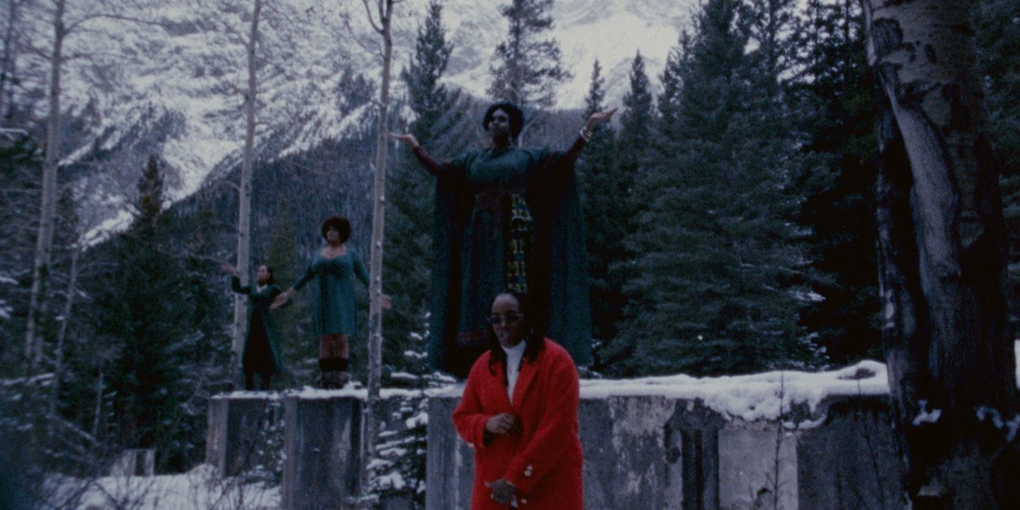 a man in a leather jacket sitting in front of a car