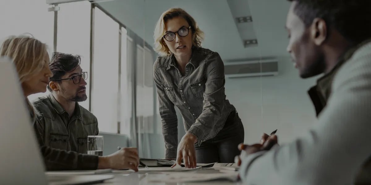 Equipe profissional colaborando durante uma reunião em uma sala de reuniões de escritório.
