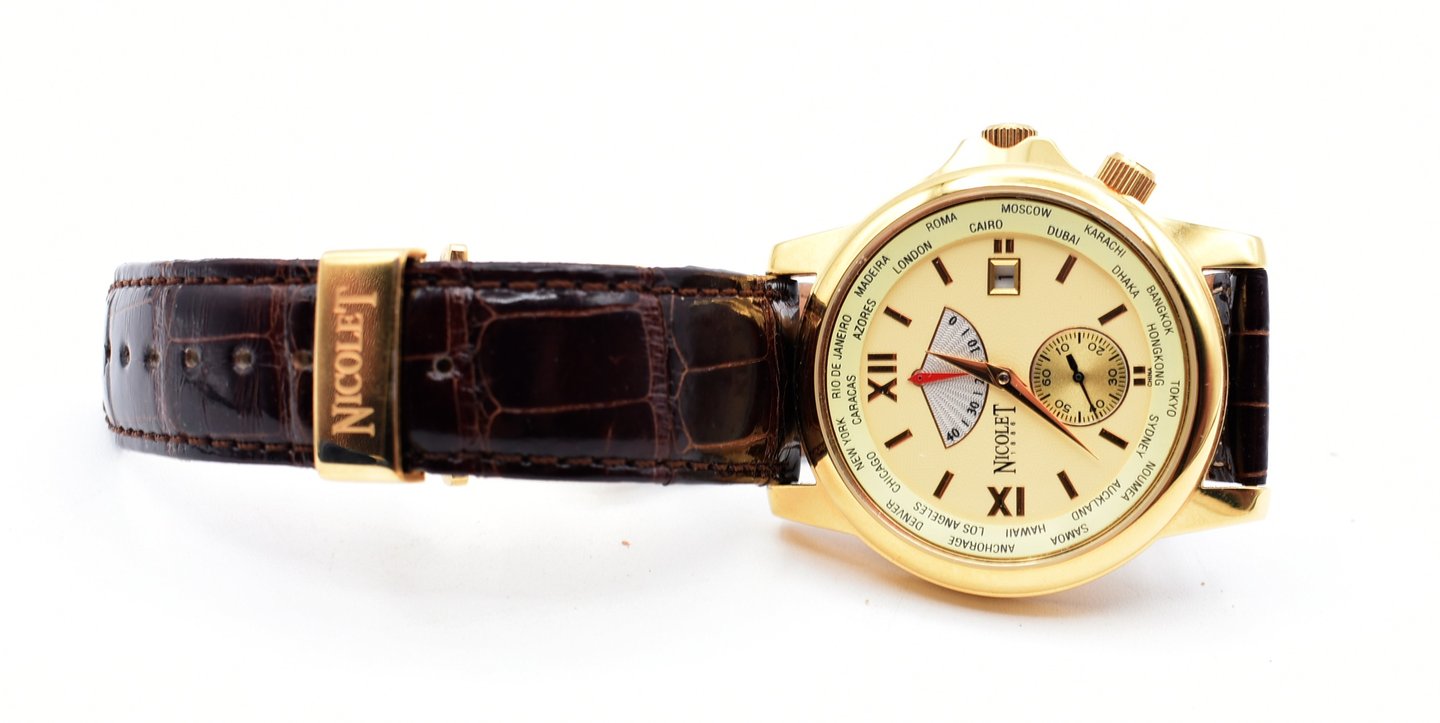Luxury Nicolet gold world timer watch featuring a brown alligator leather strap.