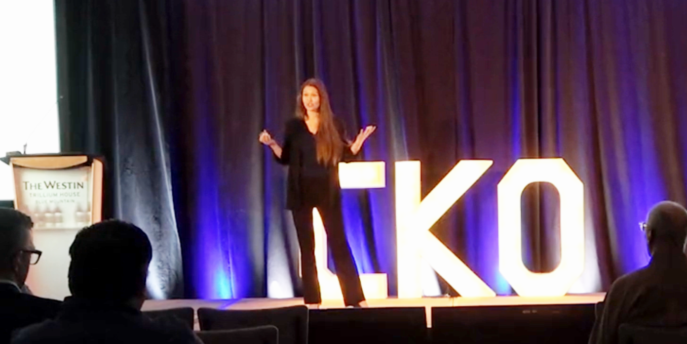 Katie on stage speaking to an audience