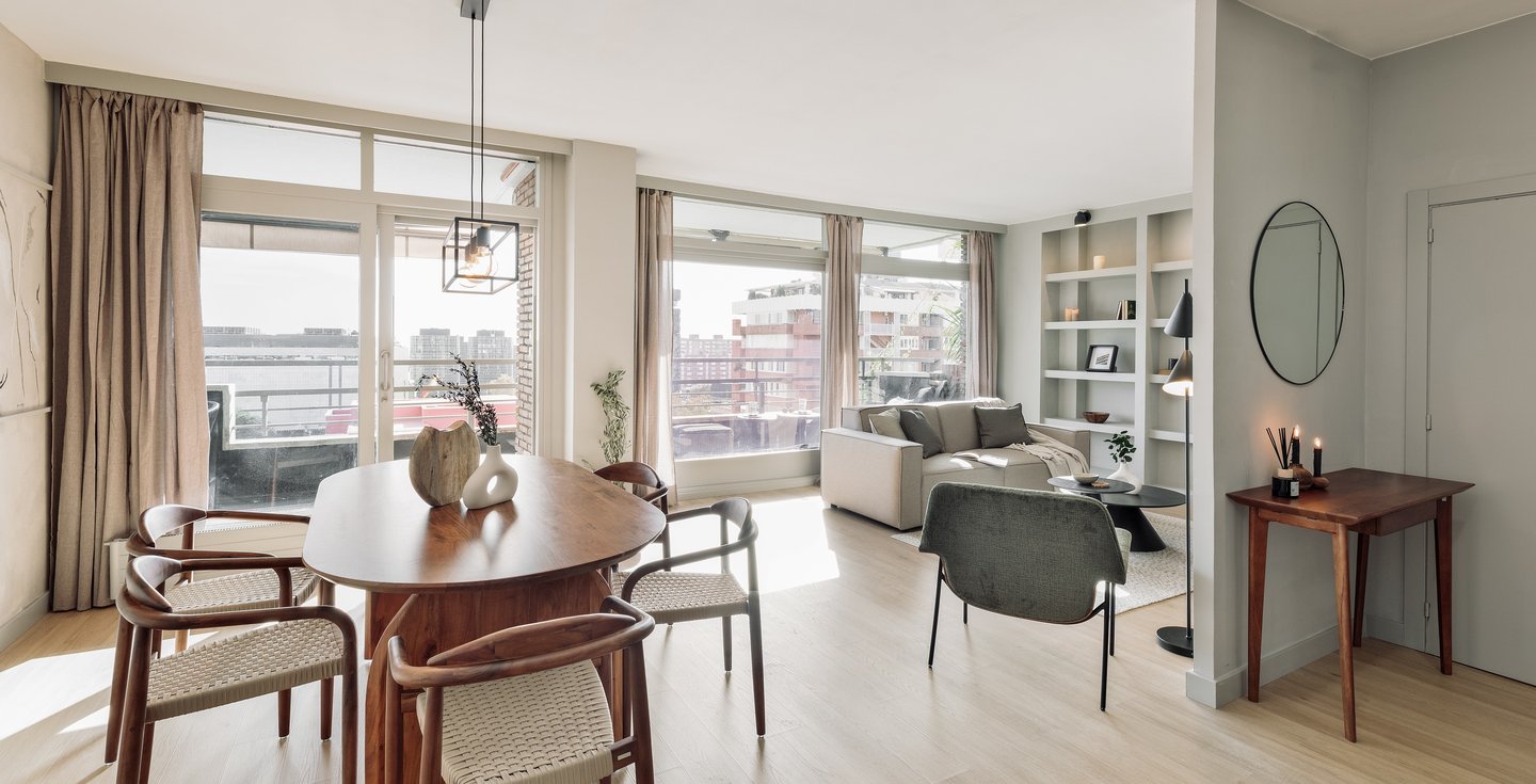 Modern dining area with metal light fixture, wooden dining table and minimalist design in Barcelona