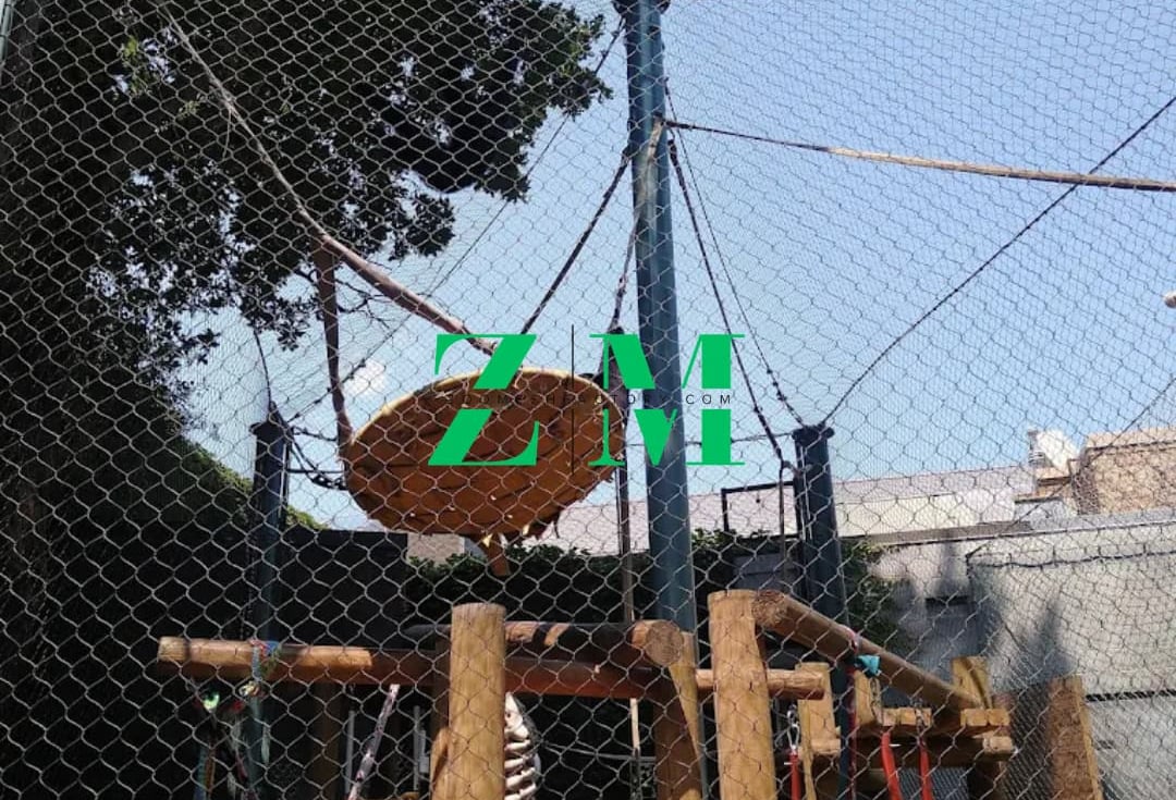 An outdoor adventure playground featuring a climbing frame, rope bridge, and safety netting.