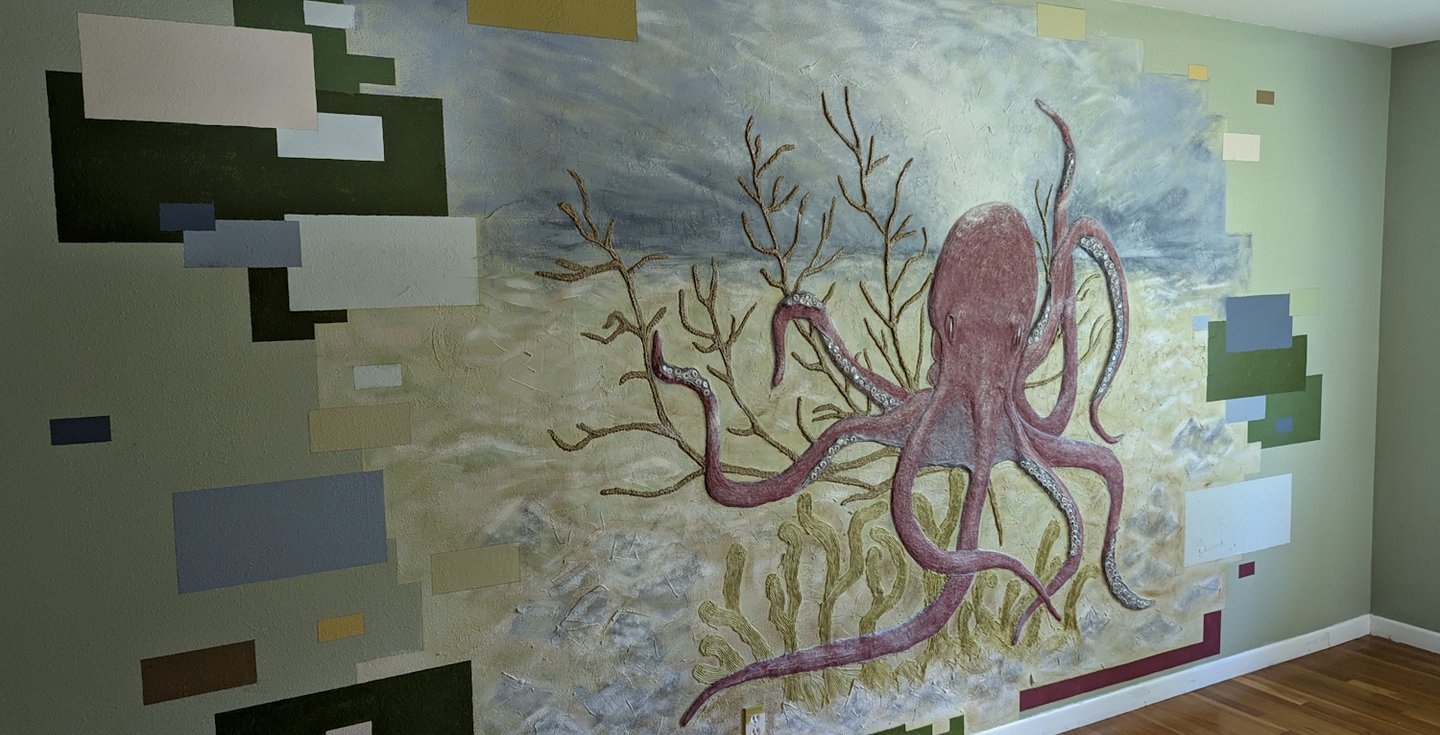 3D relief mural of an octopus in a coral bed. Green, blue seafoam green, tan, brown, yellow, cream, burgundy red colors. 