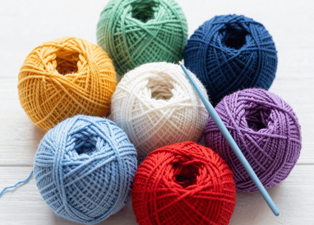 Close-up of colorful yarn balls and crochet hooks arranged invitingly on a wooden table.