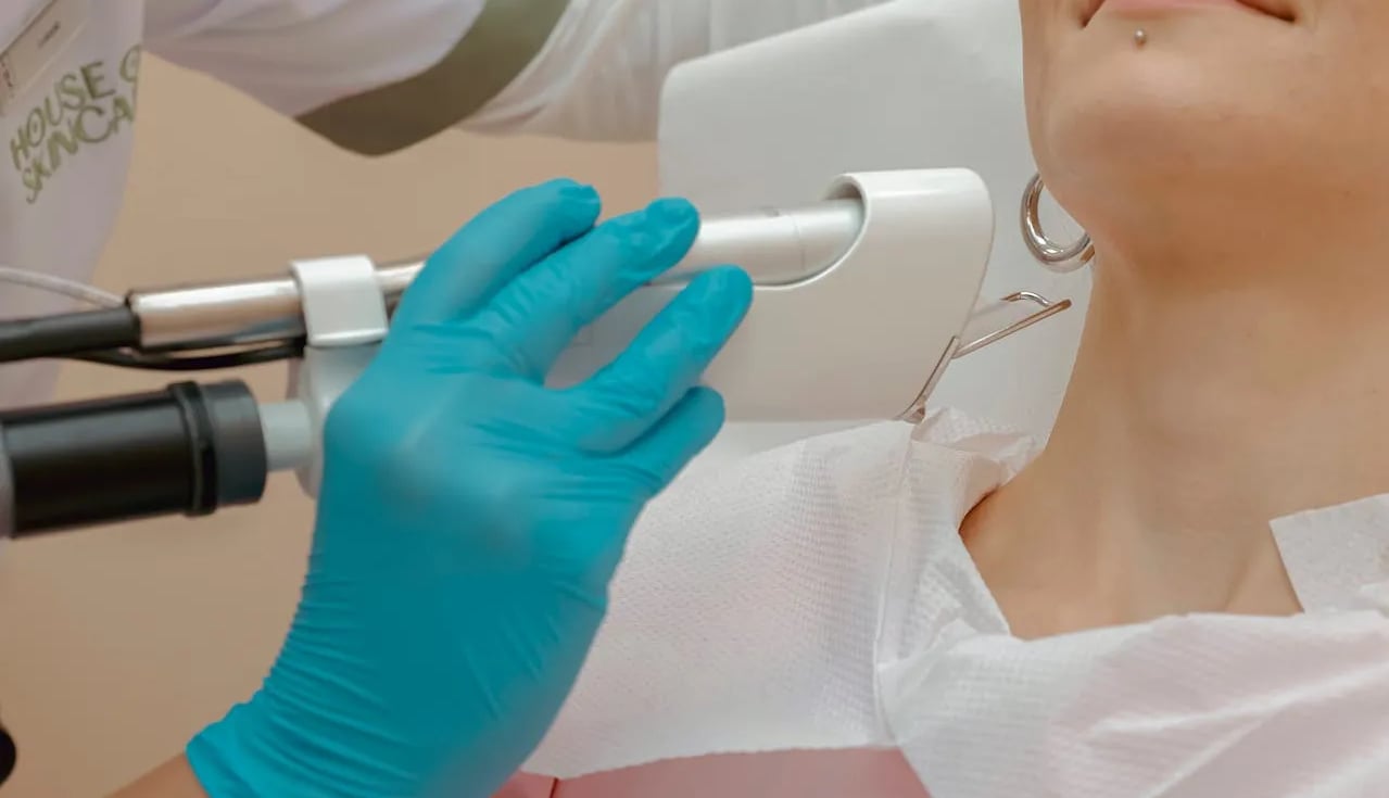 a woman is getting her teeth examined by a doctor wearing a glove.