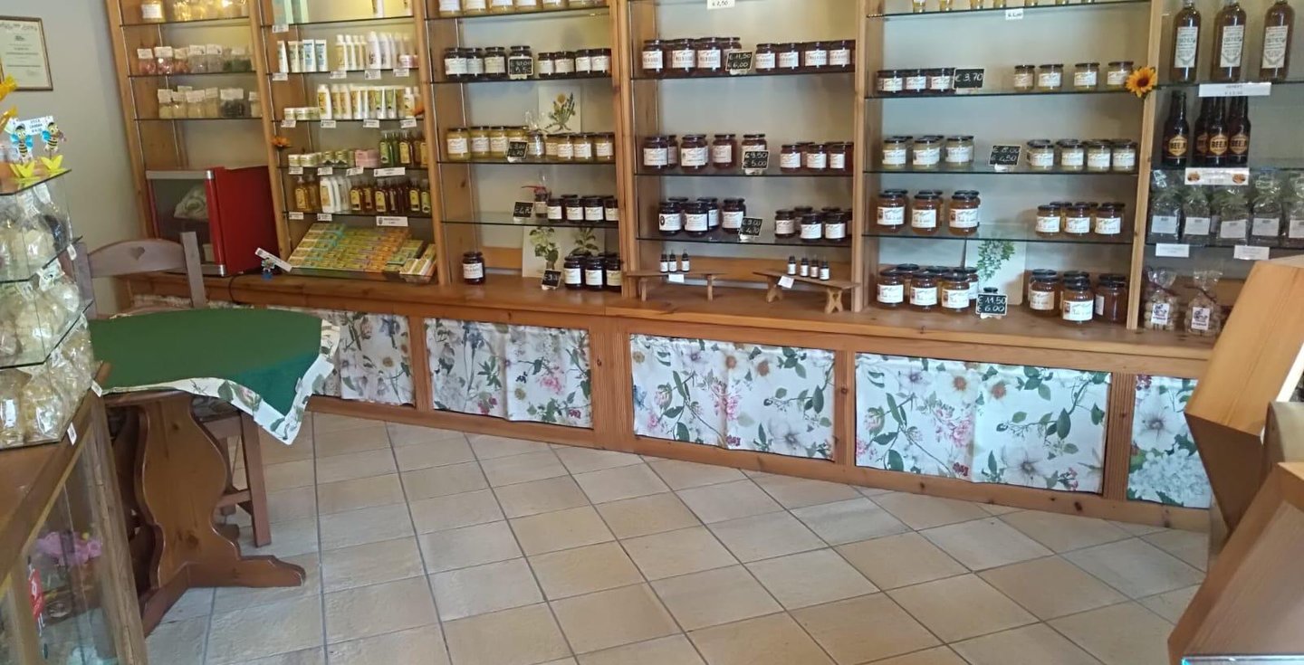 Interno del negozio a Sampeyre con miele e cosmetici esposti sugli scaffali