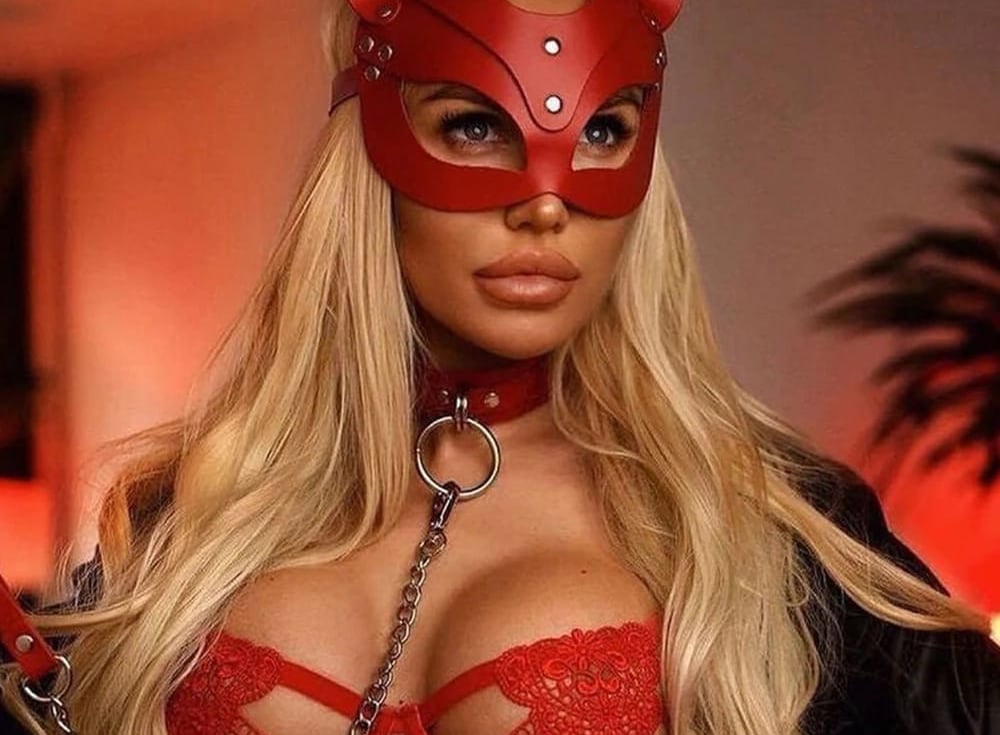 a woman in a red leather mask and red leather cat mask