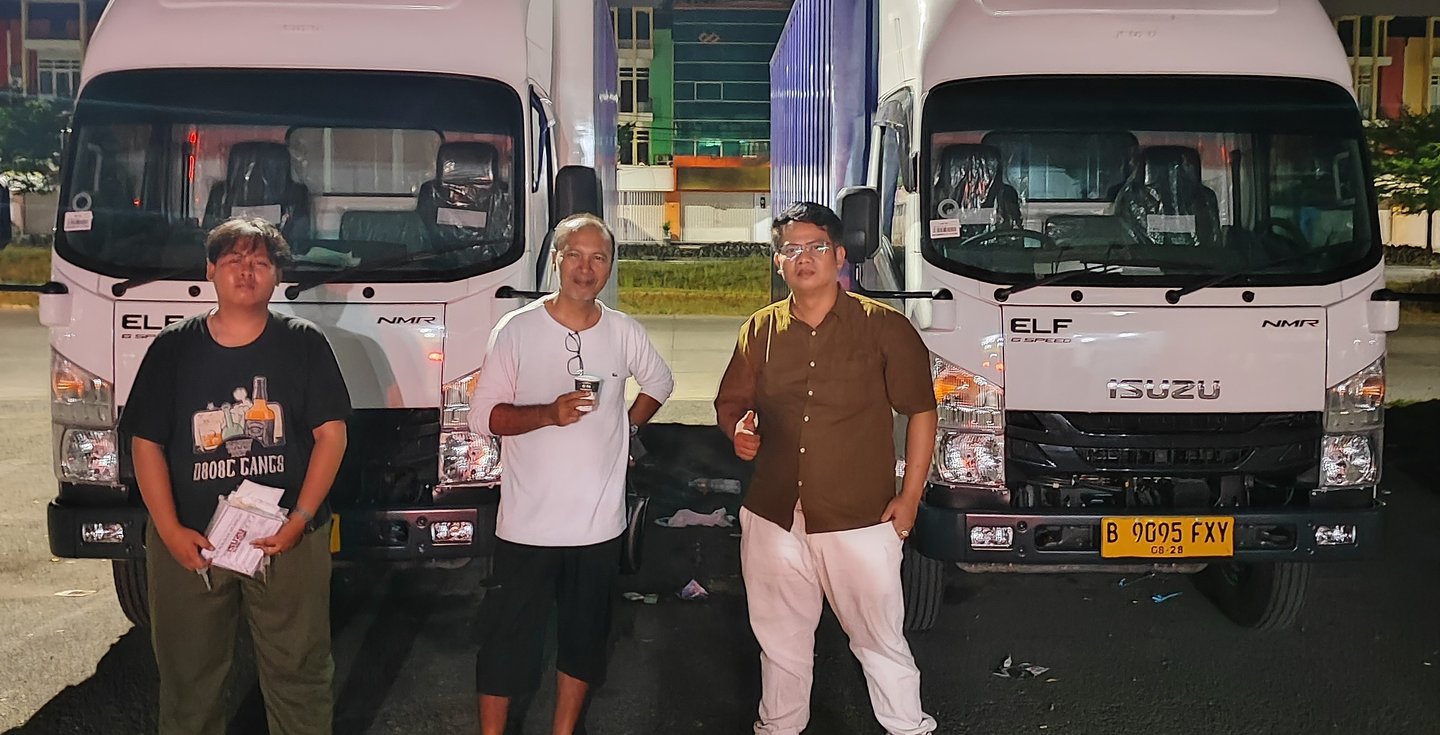 three men standing next to each other in front of a truck