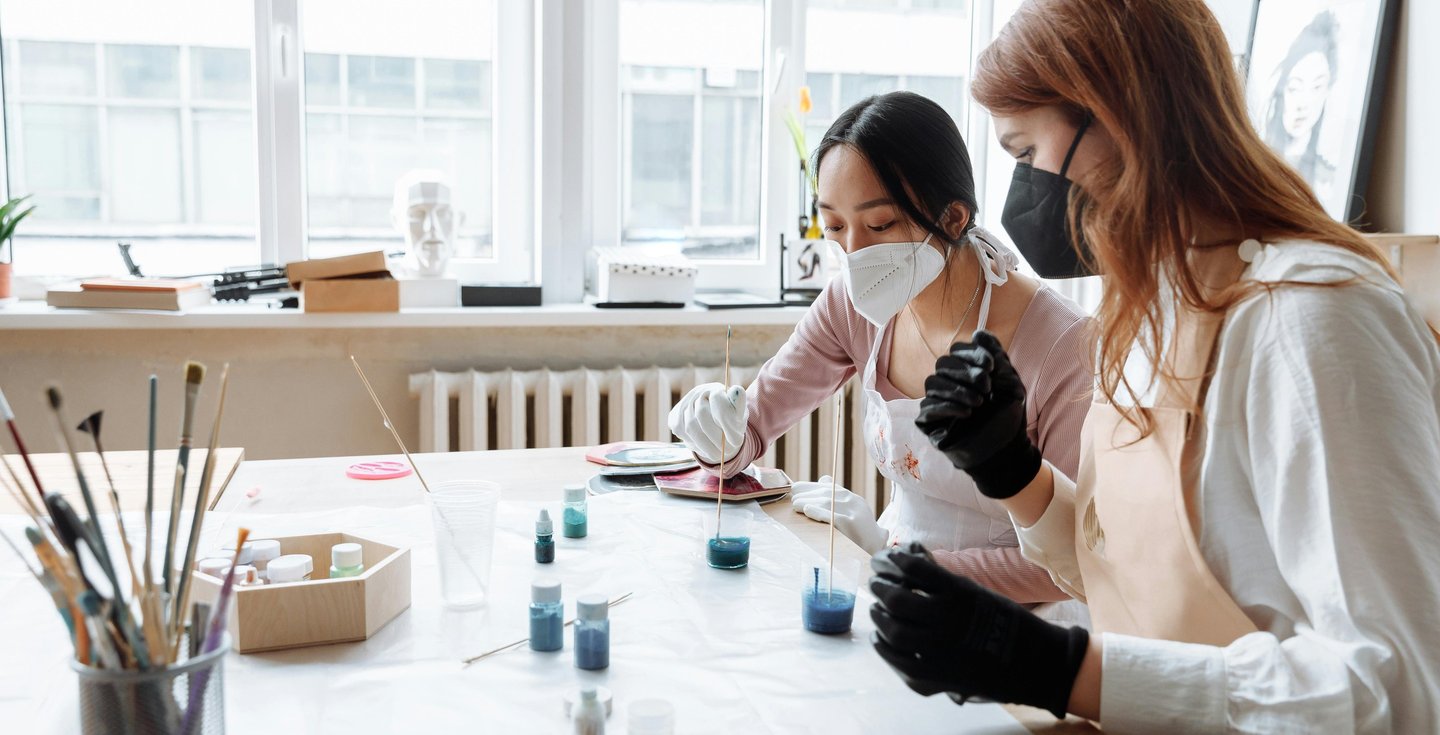 dos mujeres mesclando resina con colorante Azul en Uno's vasos