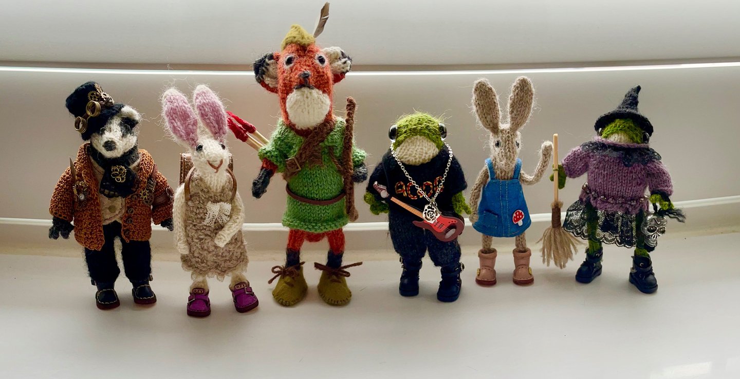 A collection of little knitted woodland animal ornaments in clothes, badgers, foxes, bunny rabbits a