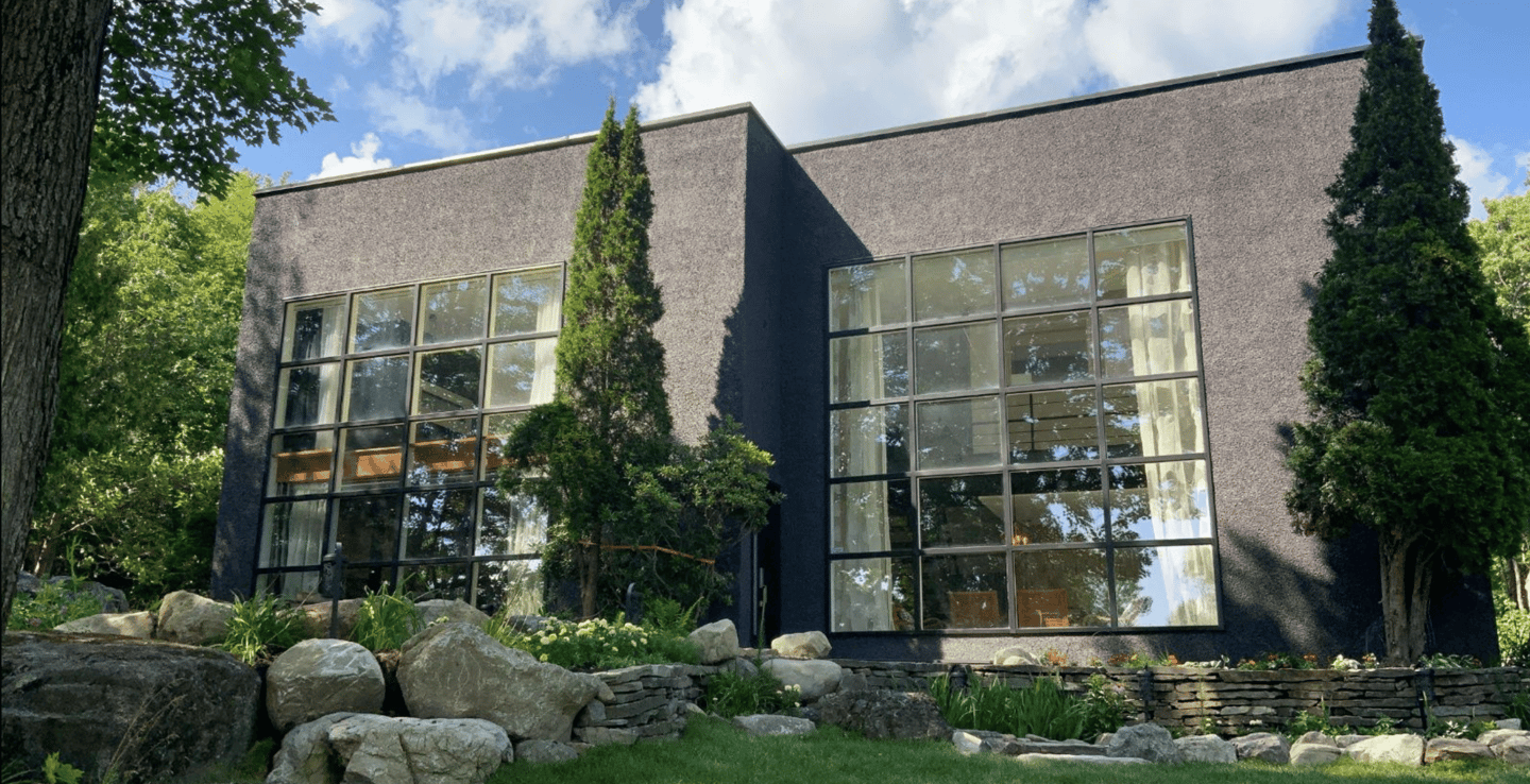 a large house with a large window and a stone wall