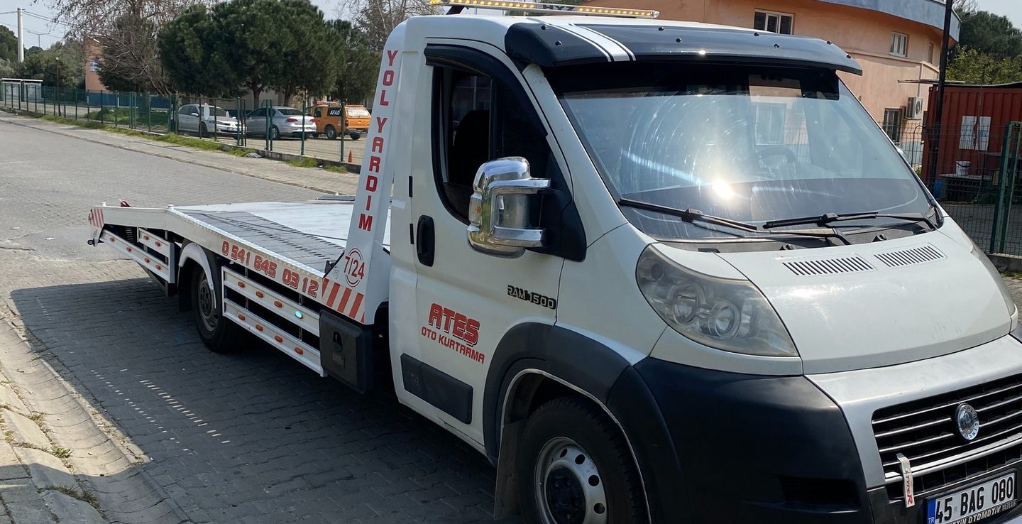 White fiat roadside assistance tow truck parked on a paved street for vehicle recovery service.