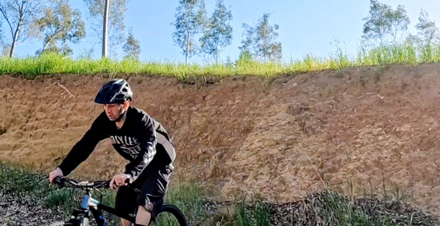mountain biker riding out of a steep roll in
