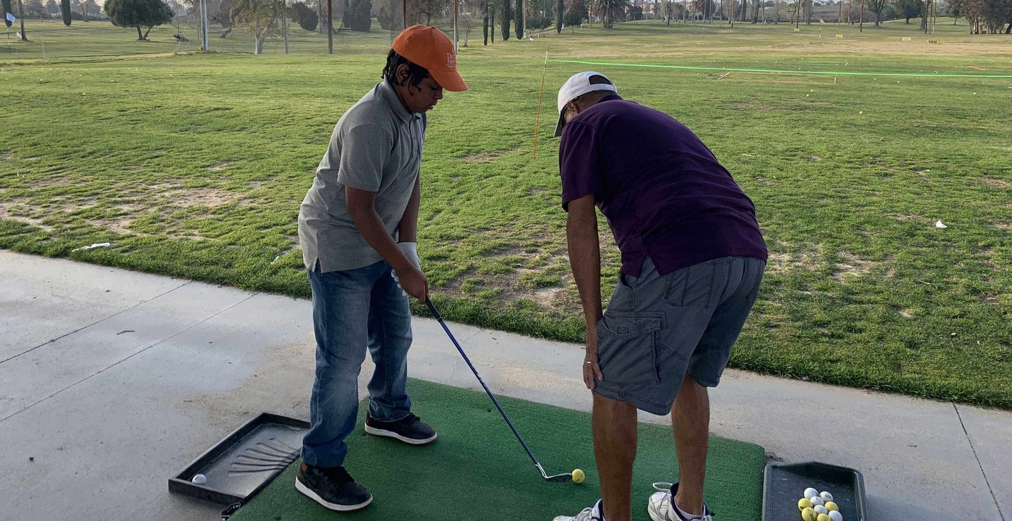 Enhancing Forward Action Inc. image young golfer being taught golf
