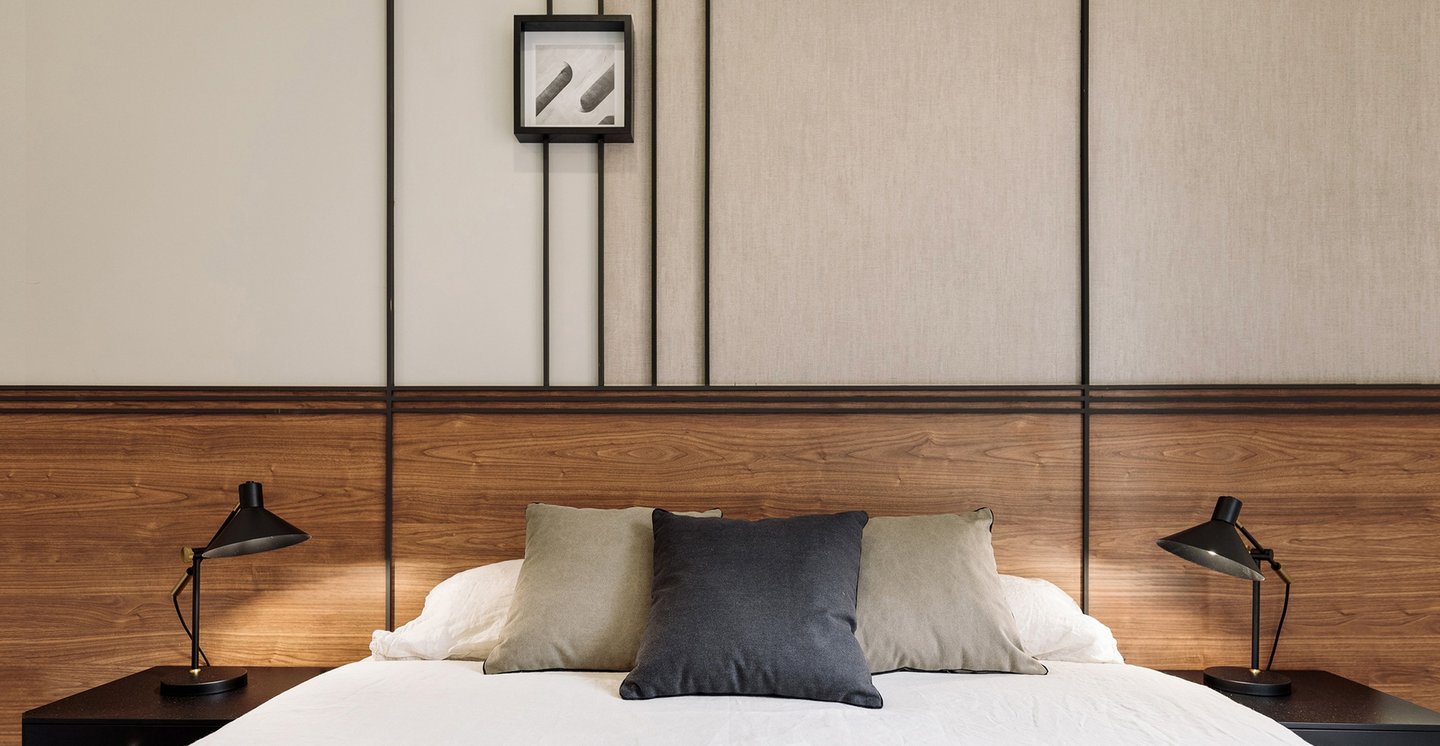 Sophisticated bedroom with natural walnut finishes, custom art pieces, and balanced design by SAVIA