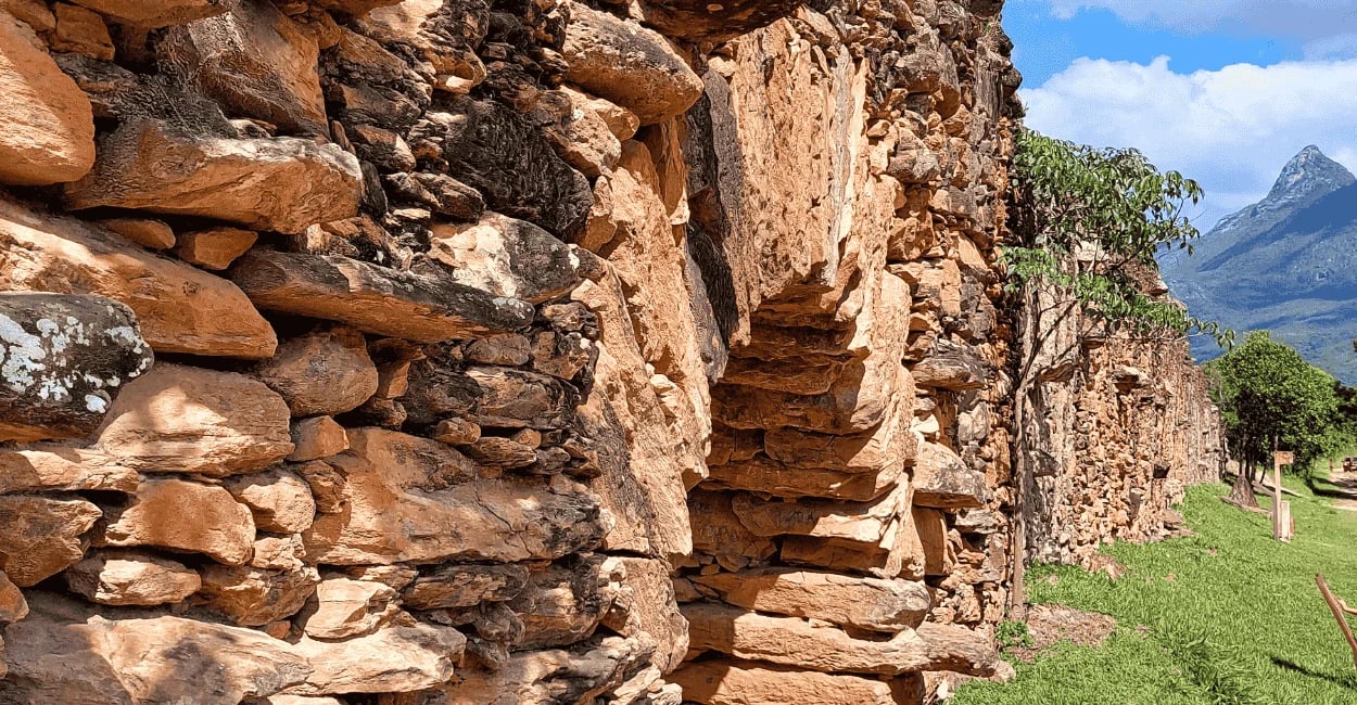 Bicame de Pedra em Catas Altas MG com estrutura de pedras antigas, gramado ao lado e serra ao fundo