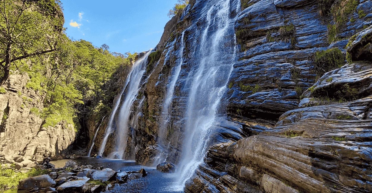 Cachoeira em Cocais com quedas d’água entre rochas, poço natural e mata ao redor