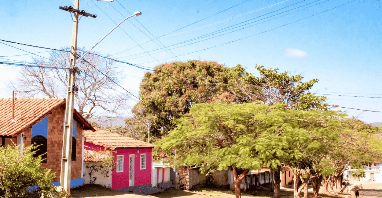 Centrinho de Conselheiro Mata MG, com casas coloridas, árvores, rua tranquila e clima de distrito