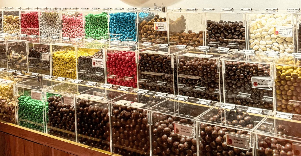 Chocolateria em Monte Verde MG com vitrine cheia de drágeas, chocolates coloridos e doces