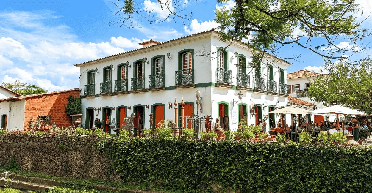 Casarão colonial com portas coloridas, varanda e restaurante movimentado em Tiradentes