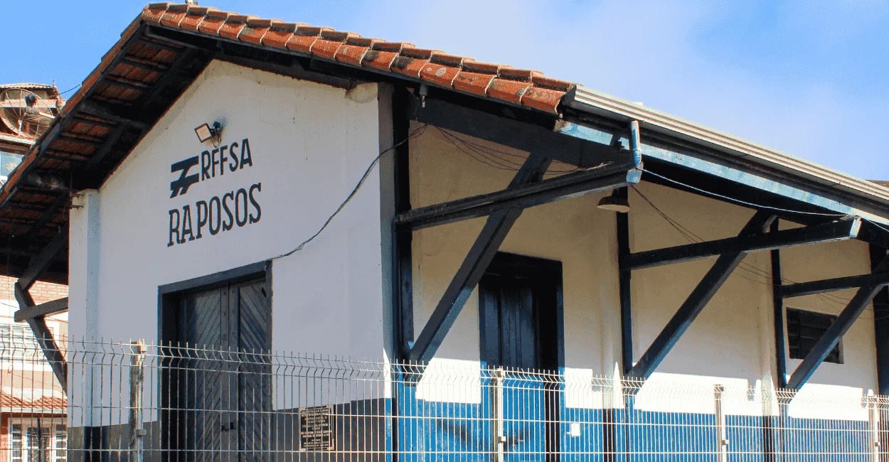 Estação ferroviária de Raposos, Minas Gerais, com fachada branca, detalhes azuis, telhado colonial