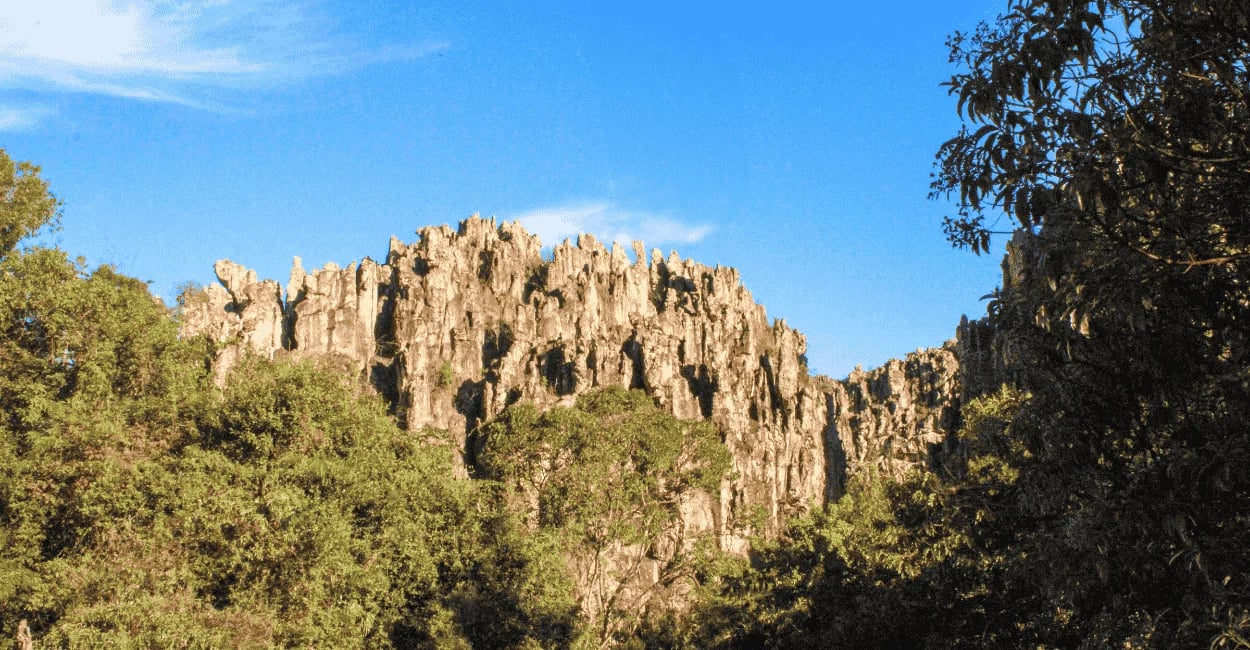 Formações rochosas da Gruta do Salitre cercadas por vegetação e céu azul em Minas Gerais