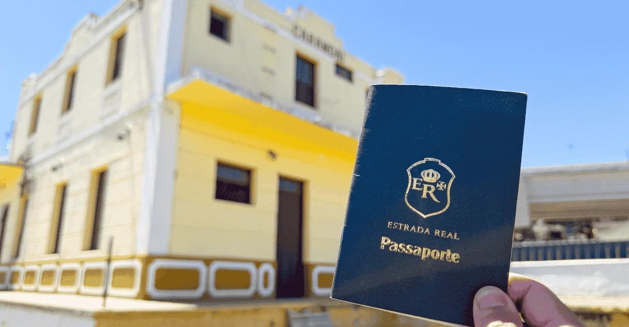 Passaporte de cor verde da estrada real em frente a estacao ferroviaria de Carandai, em Minas Gerais