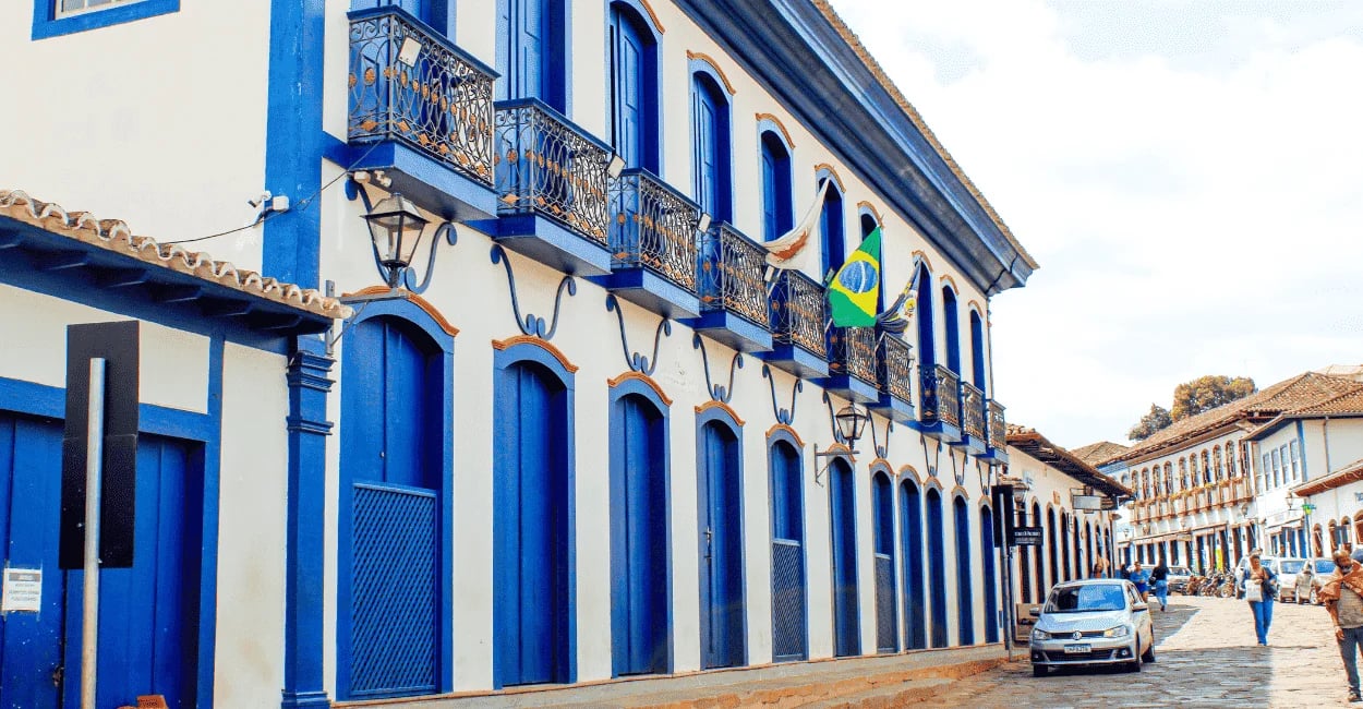 Prédio histórico de dois andares com sacadas de ferro e bandeira do Brasil no centro de Serro, Minas