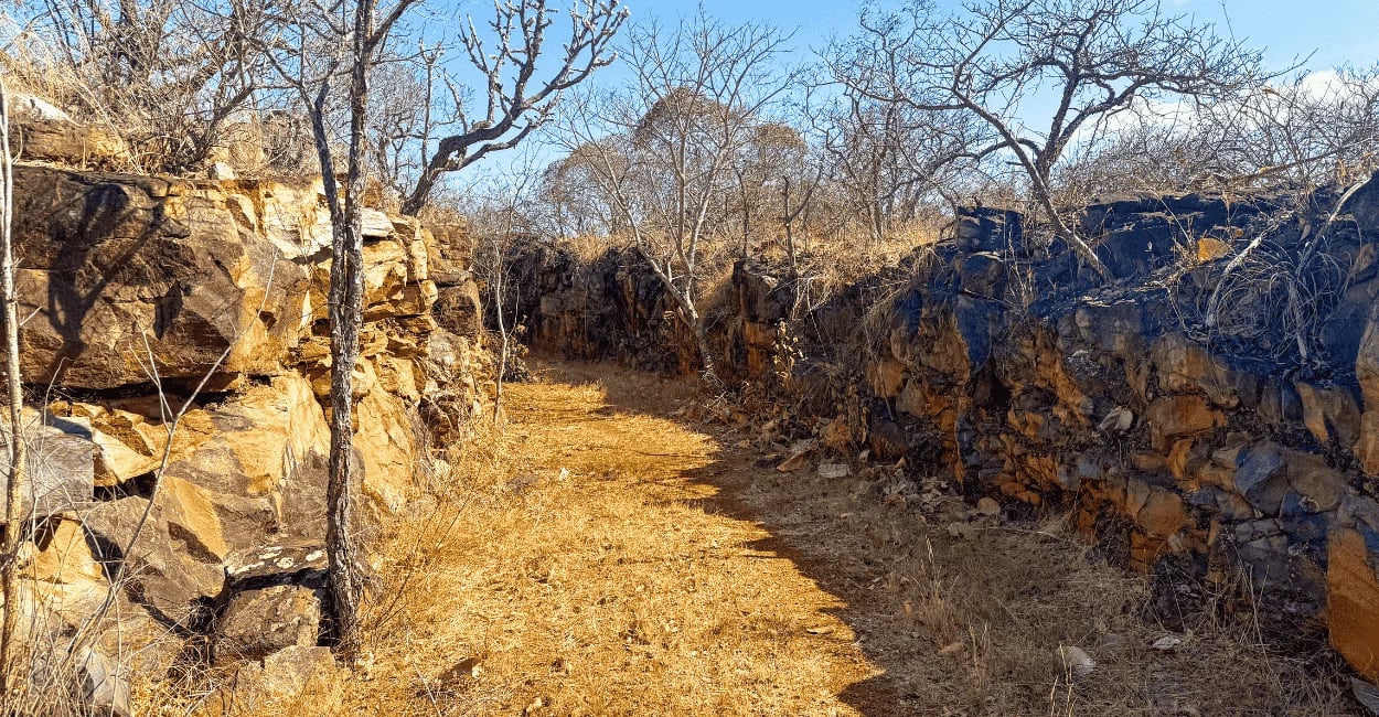 Um pedaço da Trilha Verde, com paredes de pedra e vegetação nativa do cerrado mineiro