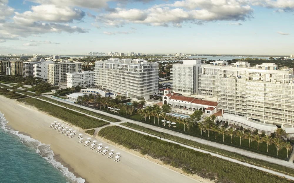 Four Seasons Surf Club historic 1930s building exterior with palm tree-lined entrance and Mediterran