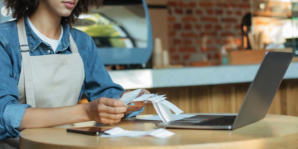 a woman in aprons and aprons is holding a credit card. Accounting- Taxes.